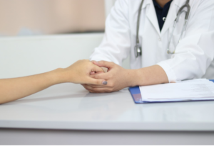 Lyme doctor consoles patient by holding her hand